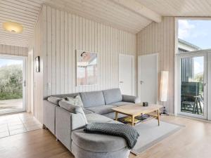 een woonkamer met een bank en een tafel bij Holiday Home Mirla - 50m from the sea in NW Jutland by Interhome in Saltum