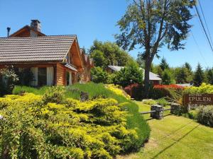 une maison avec un panneau en face d'un jardin dans l'établissement Hostería Epulén, à Villa La Angostura