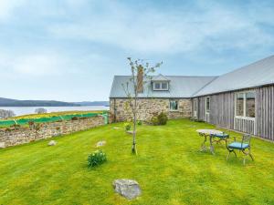 a stone house with a yard with a table and chairs at 4 Bed in Grantown-on-Spey CA383 