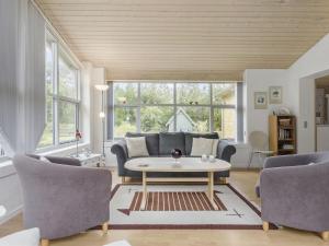 a living room with a couch and a table at Holiday Home Gisa - 500m from the sea in NW Jutland by Interhome in Fjerritslev