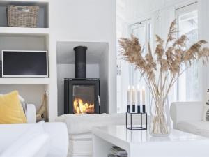a living room with a fireplace and a white couch at Holiday Home Verner - 900m from the sea in NW Jutland by Interhome in Fjerritslev