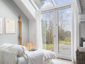 a bedroom with a bed and a large glass door at Holiday Home Verner - 900m from the sea in NW Jutland by Interhome in Fjerritslev