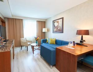 a living room with a blue couch in a hotel room at Dedeman Konya Hotel Convention Center in Konya +163 photos