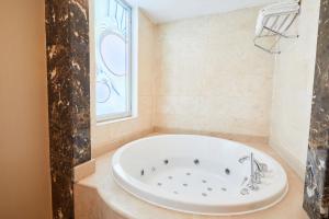 a bath tub in a bathroom with a window at Dedeman Konya Hotel Convention Center in Konya