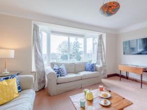 uma sala de estar com um sofá e uma mesa em 3 Bed in West Bay 78089 em Bridport