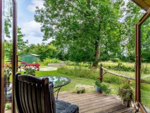 a porch with a glass table and a view of a yard at 1 Bed in Beccles 78766 in Beccles