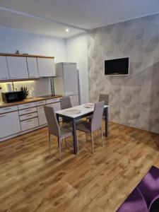 ein Esszimmer mit einem Tisch und Stühlen in einer Küche in der Unterkunft Karolina in Daugavpils