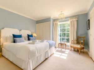 een slaapkamer met een groot wit bed en een raam bij 5 Bed in Litton Cheney 78462 in Long Bredy