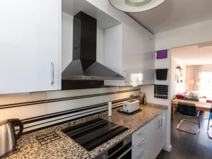 a kitchen with white cabinets and a black stove top oven at Apartment Como Siempre by Interhome in Vinarós