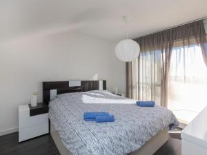 a bedroom with a bed with two blue pillows on it at Apartment Como Siempre by Interhome in Vinarós
