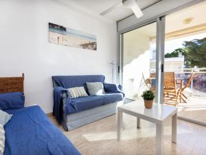 a living room with a blue couch and a table at Apartment Cala Llobeta by Interhome in L'Ametlla de Mar