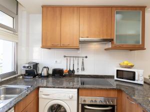a kitchen with a sink and a washing machine at Apartment Cala Llobeta by Interhome in L'Ametlla de Mar