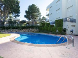 a swimming pool in front of a building at Apartment Cala Llobeta by Interhome in L'Ametlla de Mar +22 photos