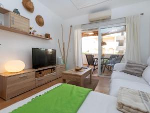 a living room with a couch and a tv at Apartment Om by Interhome in Vinaròs