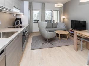 a kitchen and living room with a couch and a table at Holiday Home Rukachalet 2407 by Interhome in Ruka