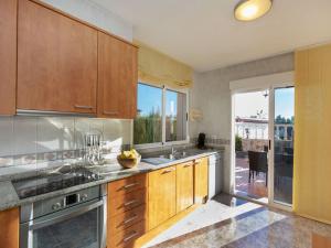 a kitchen with wooden cabinets and a large window at Holiday Home Wunder Haus by Interhome in Vinarós