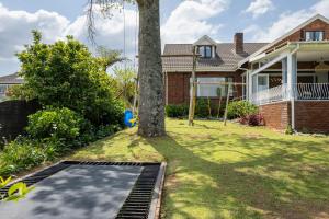 a tree in the yard of a house with a trampoline at Bergview Apartments in Hilton