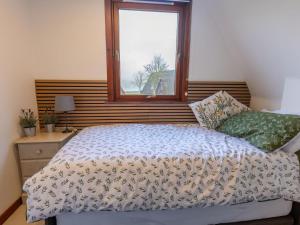 a bedroom with a bed and a window at Chalet Caledonia Lodge by Interhome in Spean Bridge