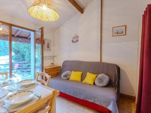 Un dormitorio con una cama con almohadas amarillas y una mesa. en Holiday Home Bois d'Eleis-3 by Interhome, en Les Mathes