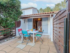 un patio con mesa y sillas. en Holiday Home Bois d'Eleis-3 by Interhome, en Les Mathes