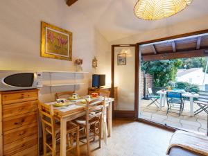 cocina con mesa y comedor con patio en Holiday Home Bois d'Eleis-3 by Interhome, en Les Mathes