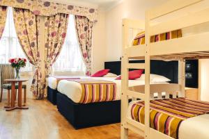 a bedroom with two bunk beds and a table at Athena Hotel in London