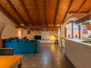 Apartment Lagoni by Interhome في أرونا: مطبخ وغرفة معيشة مع أريكة زرقاء