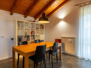 uma sala de jantar com uma mesa de madeira e cadeiras em Apartment Lagoni by Interhome em Arona
