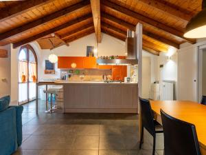 uma cozinha com armários laranja e uma mesa de madeira em Apartment Lagoni by Interhome em Arona