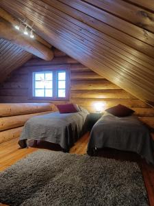 sypialnia z 2 łóżkami w drewnianym domku w obiekcie Riverside Villa w mieście Rovaniemi
