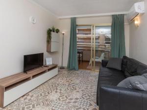 ein Wohnzimmer mit einem Sofa und einem TV in der Unterkunft Apartment Jerez-3 by Interhome in Salou