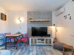 - un salon avec une télévision, une table et des chaises dans l'établissement Studio Modern Cave by Interhome, à Split