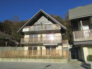 a large house with a wooden fence in front of it at Apartment Iris in Bohinj