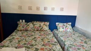 two beds sitting next to each other in a bedroom at Bangalô Amarelo in Prado