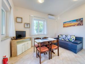 ein Wohnzimmer mit einem Tisch und einem blauen Sofa in der Unterkunft Apartment JF Rezine by Interhome in Lovran
