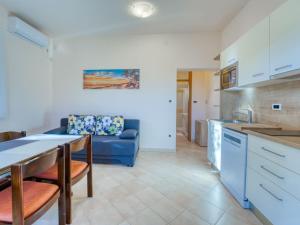 eine Küche und ein Wohnzimmer mit einem blauen Sofa in der Unterkunft Apartment JF Rezine by Interhome in Lovran