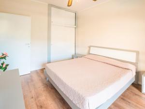 a white bedroom with a bed in a room at Apartment Magnolia-16 by Interhome in Marina di Bibbona