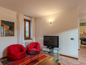 - un salon avec deux chaises rouges et une télévision à écran plat dans l'établissement Holiday Home Marianna by Interhome, à Oria