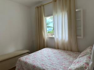 a bedroom with a bed and a window at Refúgio dos gatos in Ubatuba