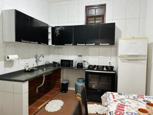 uma cozinha com um lavatório e um frigorífico em Refúgio dos gatos em Ubatuba