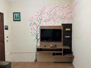 a wall mural of a tree with pink flowers at Refúgio dos gatos in Ubatuba