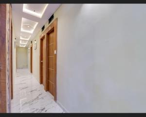 an empty hallway with wooden doors and marble floors at Hotel new views in Ahmedabad