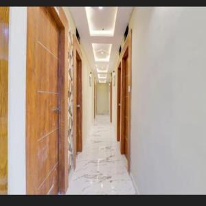 an empty hallway in a building with wooden doors at Hotel new views in Ahmedabad