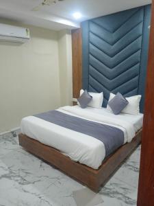 a bedroom with a large bed with a blue headboard at Hotel new views in Ahmedabad