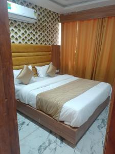 a bed with white sheets and pillows in a room at Hotel new views in Ahmedabad