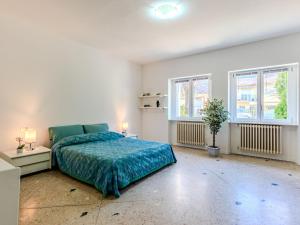 a bedroom with a bed and two windows at Apartment Betulla-2 by Interhome in Dervio