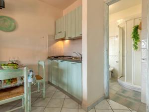 een keuken met een wastafel en een tafel in een kamer bij Apartment C11 - F4 by Interhome in Golfo Aranci
