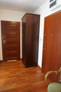 ソポトにあるHome3city Przystanek Sopotの木製のドア2つ、ウッドフロアの客室です。