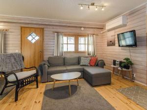 a living room with a couch and a tv at Holiday Home Kulta-käkönen 17 by bomba by Interhome in Nurmes