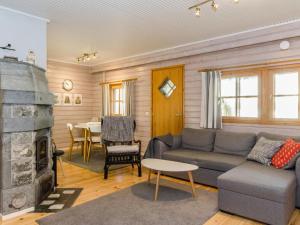 - un salon avec un canapé et une cheminée dans l'établissement Holiday Home Kulta-käkönen 17 by bomba by Interhome, à Nurmes